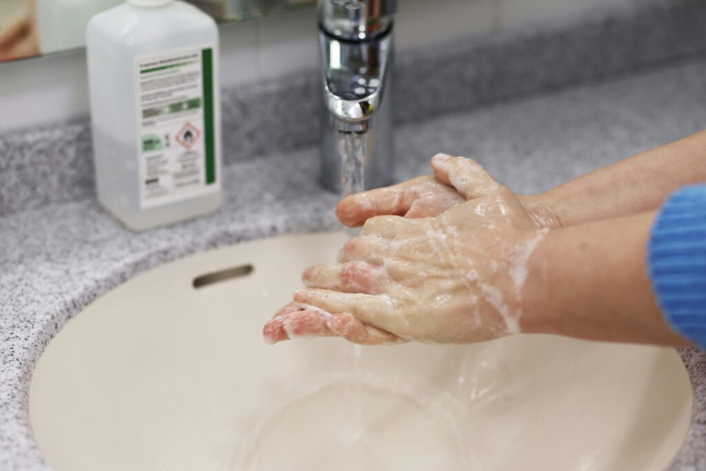 Image of a person washing their hands. Hand-washing is an example of an inexpensive and easily adopted public health intervention that reduces the spread of communicable diseases.